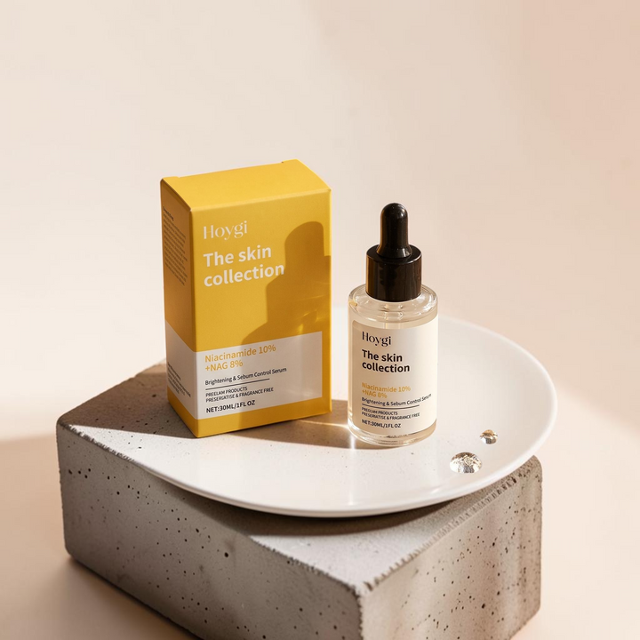 TheGromify Nicotinamide Brightening Face Serum bottle and yellow box on a white plate and concrete block display.